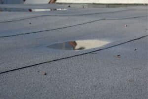 Ponding Water On Flat Roofs: Causes & Fixes