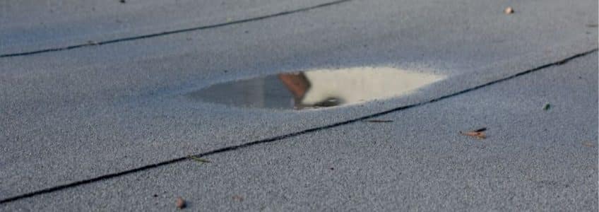 Ponding Water On Flat Roofs: Causes & Fixes