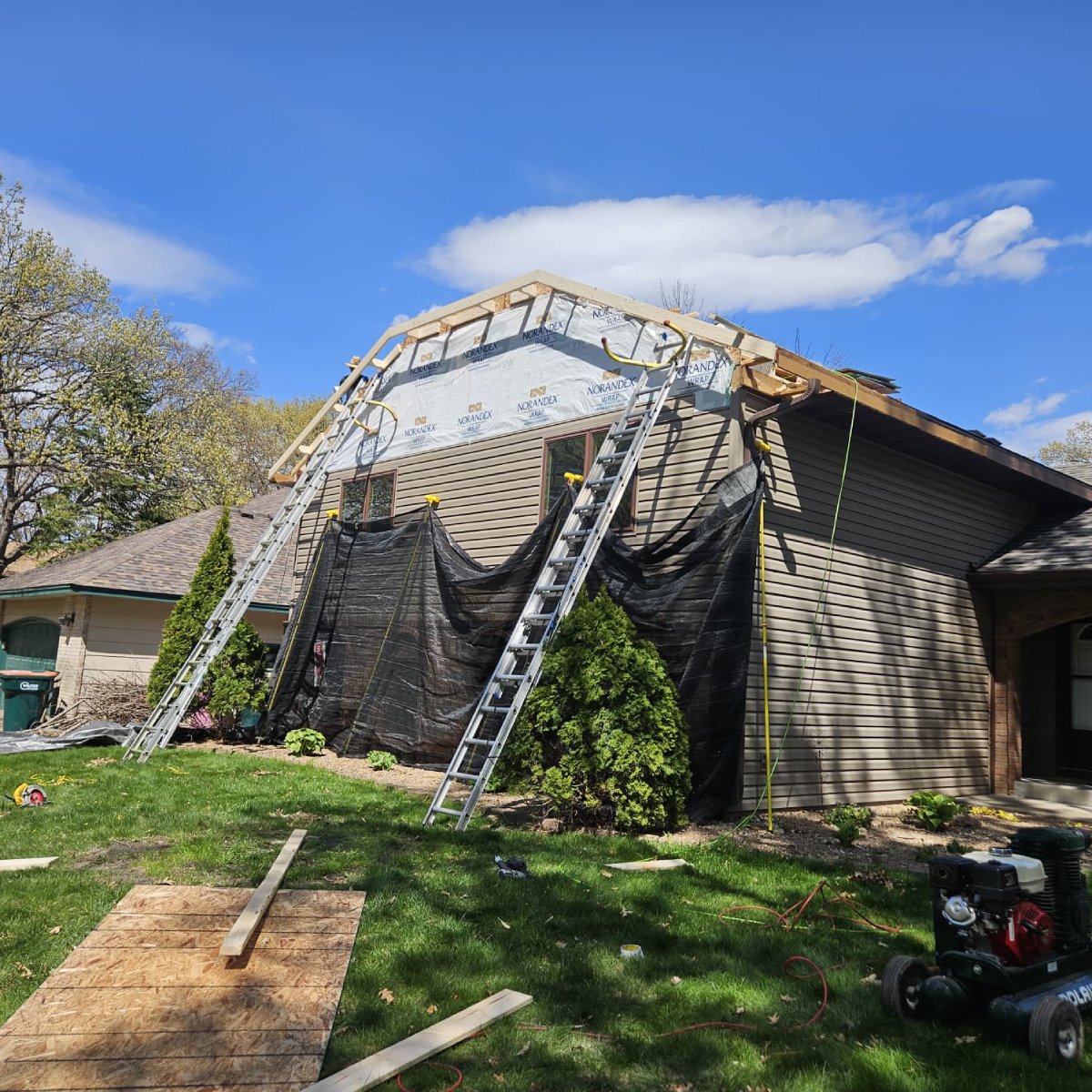 Emergency tarp protecting the damaged roof and gable of a Blaine home
